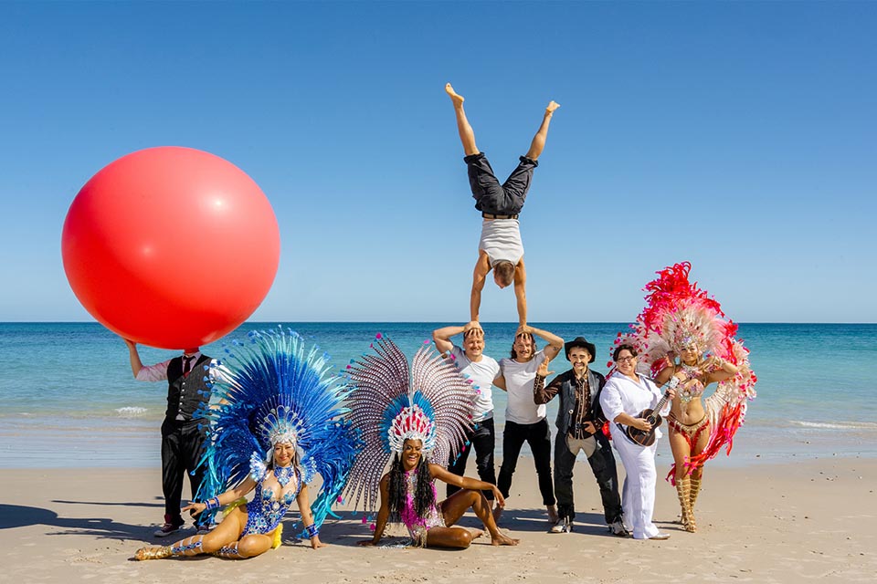 Group of performers in costume assembled on a beach
