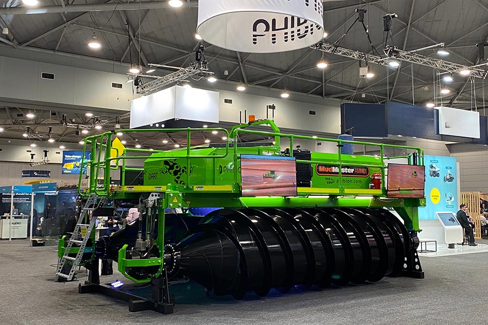 Large green robotic machine on display at an exhibition