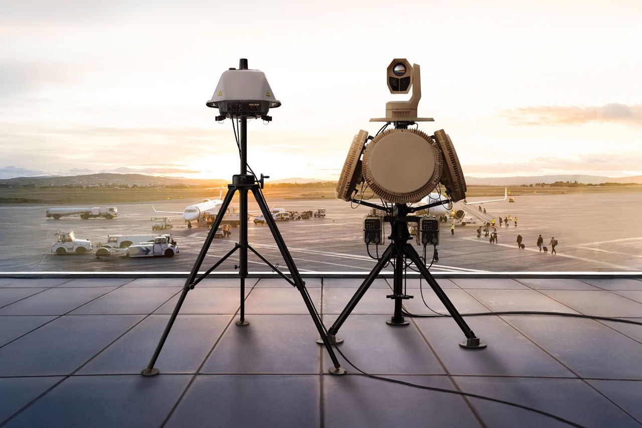 Airplanes on the airport runway. Operators loading and unloading and people boarding the planes. Airport at sunset