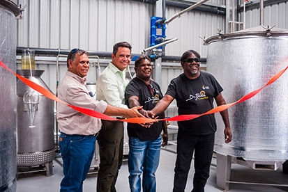 4 employees cutting ribbon at factory launch