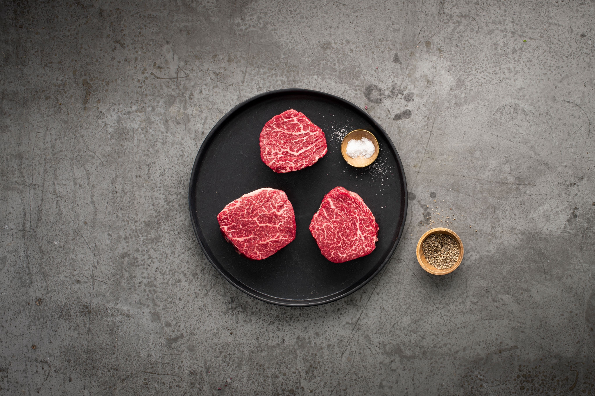 three-raw-steaks-on-plate