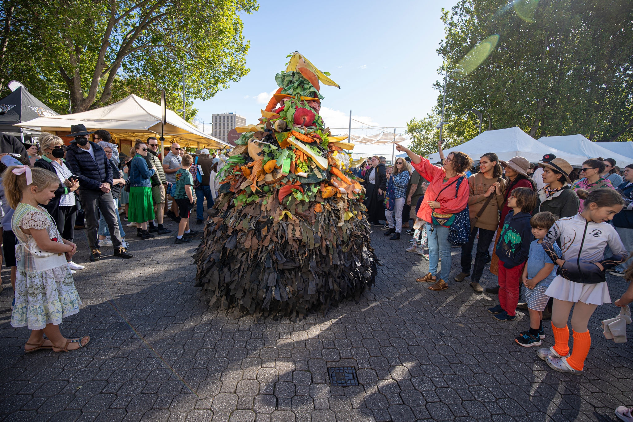 mascot-dressed-in-pile-of-vegetables-costume-performing-for-a-group-of-people