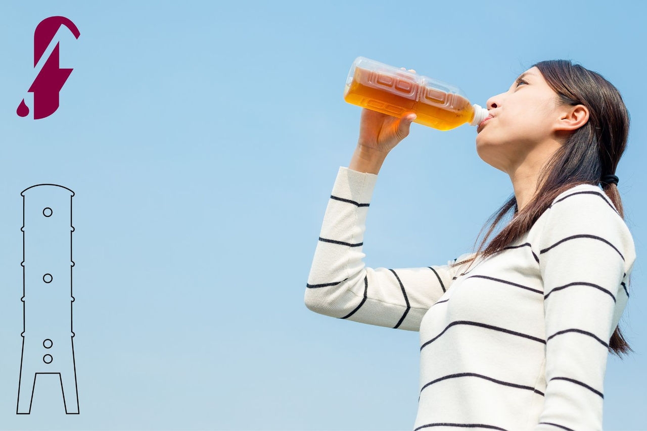 a female drinking an orange-coloured liquid from a plastic bottle