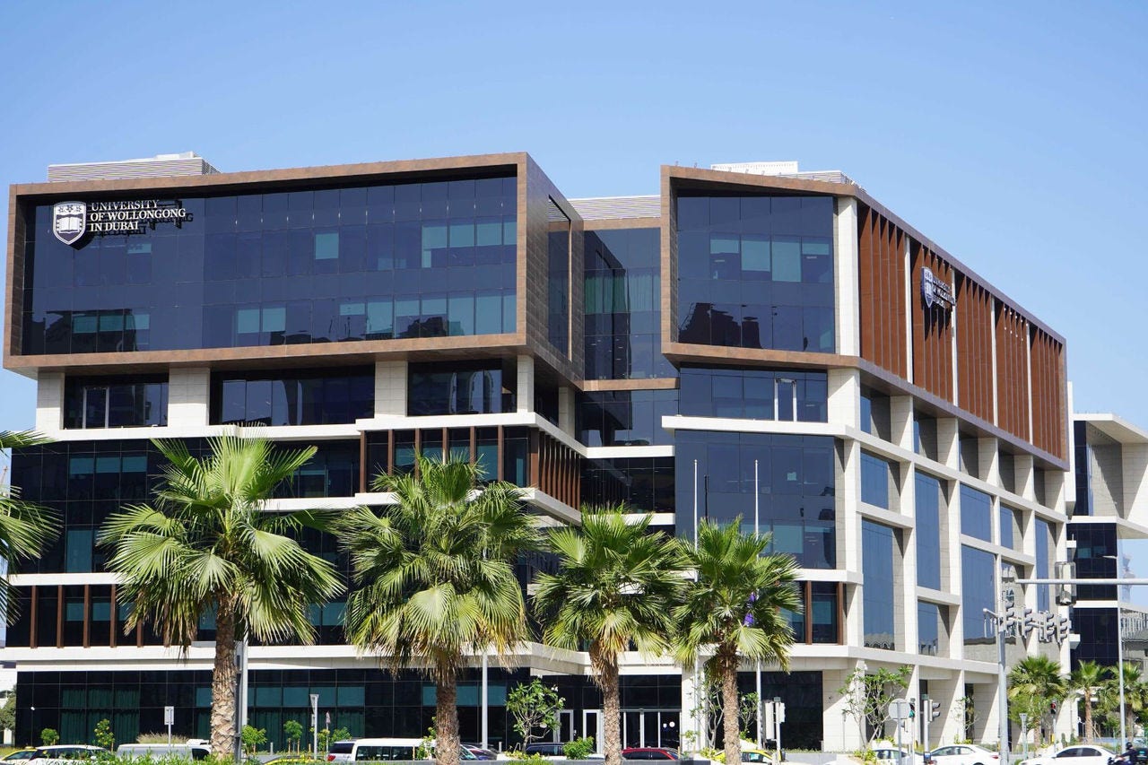 a modern building with palm trees planted along the front