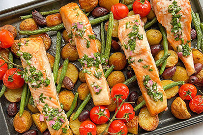Salmon cooked with herbs, tomatoes and olives on a plate