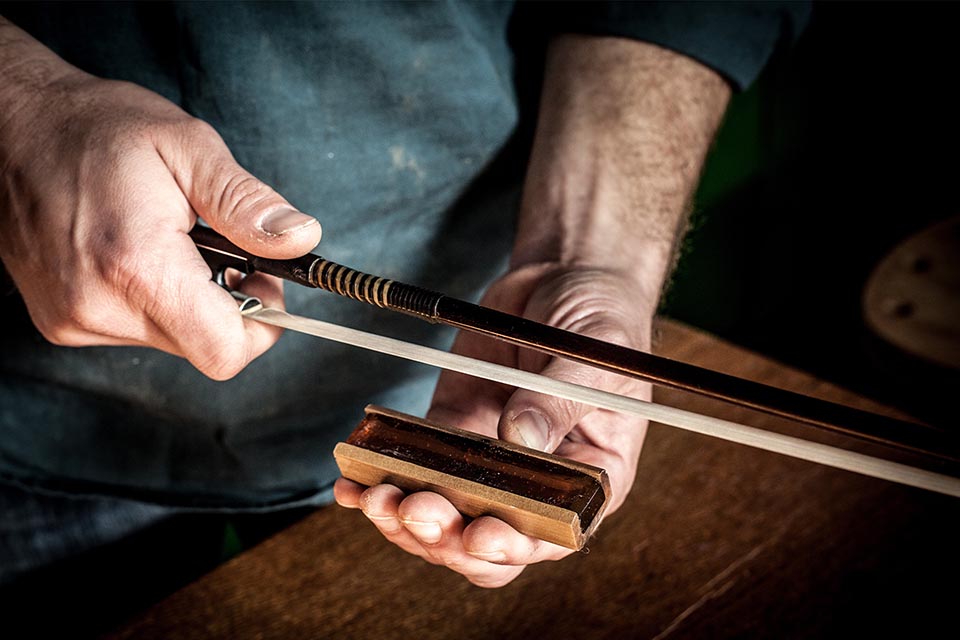 Person holding a bow with leather tool