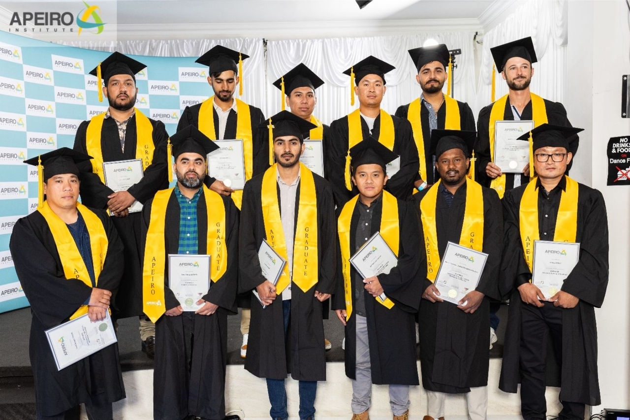 a group photo of men and women graduates dressed in black and yellow graduation gowns holding their certificates