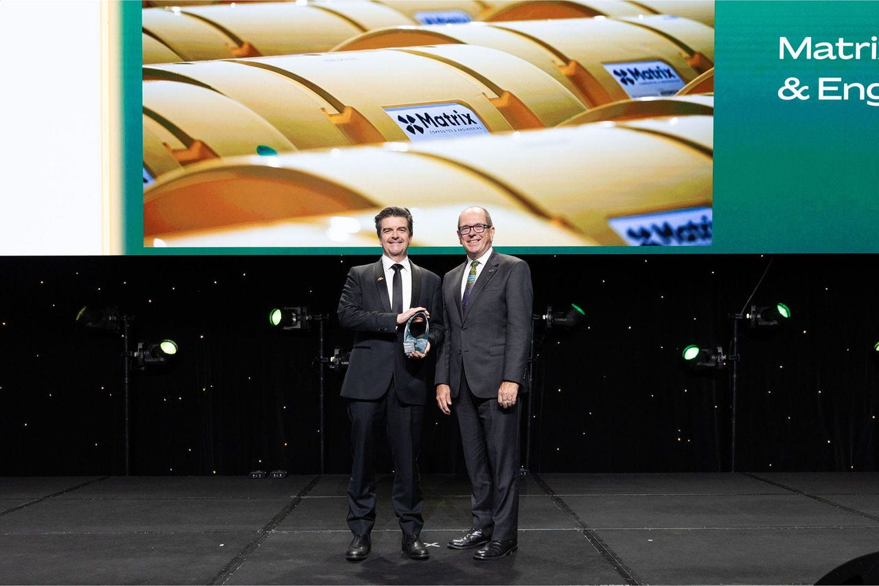People on a stage receiving an award.
