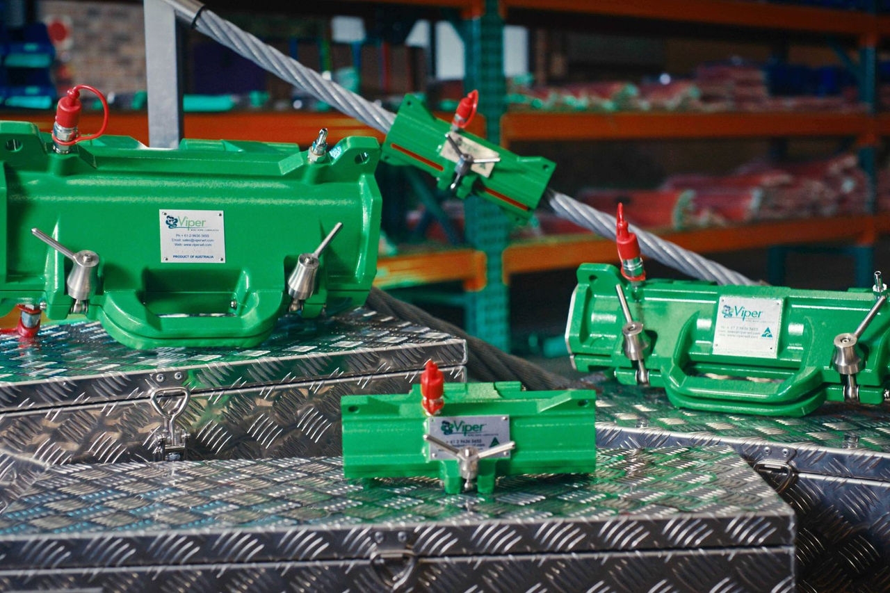 A range of green metal manufactured parts sit on steel checkerplate