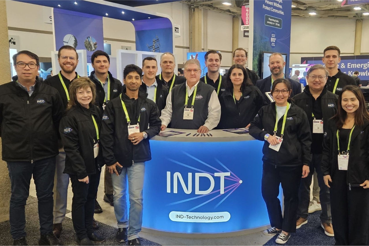 A group of men and women pose at a conference booth