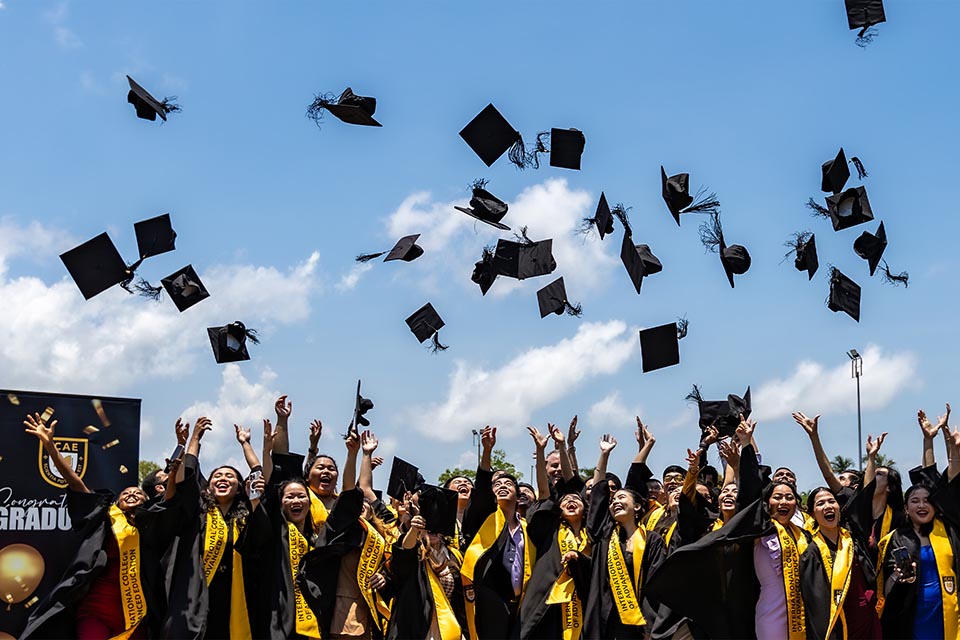 Group of graduates throwing their mortar board hats in the air