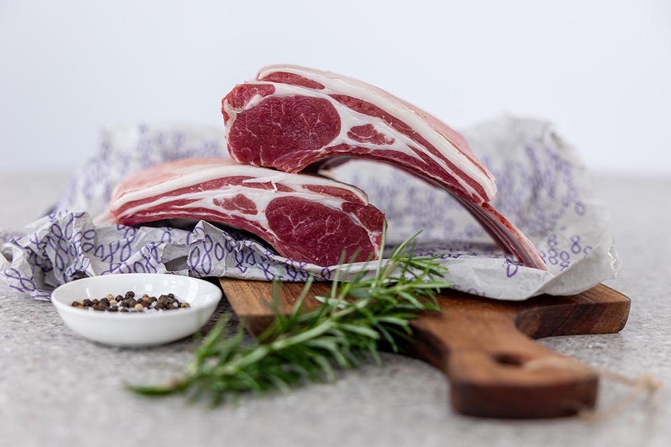 Two racks of lamb with rosemary sprig and peppercorns