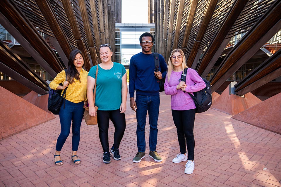 4 students standing on pathway at University