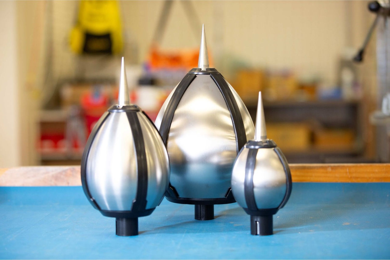 Three stainless steel lightning conductors of different sizes sit on a table