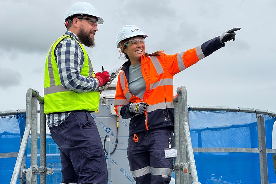 Two people wearing high vis on site at water plant